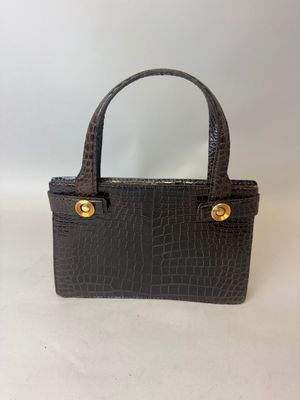 un petit sac à main noir avec des finitions dorées sur la poignée