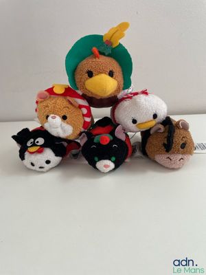 five stuffed animals sitting together on a white surface