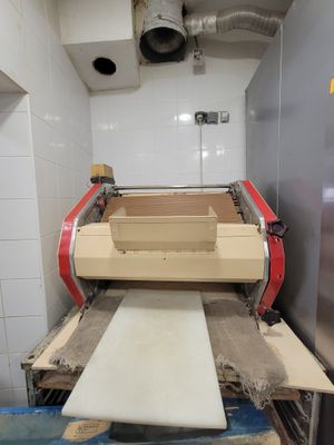 une machine qui prépare des pizzas dans une cuisine