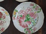 two plates with flowers painted on them sitting on a table