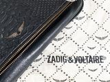a black purse sitting on top of a white table cloth