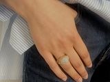 woman wearing a white shirt and blue jeans with a ring on her finger