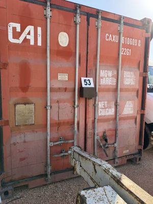a red shipping container sitting on the side of the road