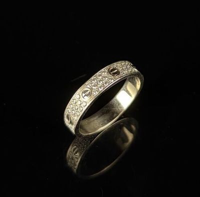 gros plan d'une bague en argent sur une surface noire