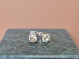 une paire de boucles d'oreilles en diamant posée sur un coffret en marbre