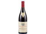 a bottle of red wine sitting on top of a white table