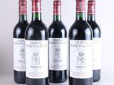 quatre bouteilles de vin sont alignées sur une surface blanche