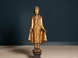 une statue en or représentant une personne debout sur un socle