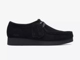 un gros plan d'une chaussure noire sur fond blanc