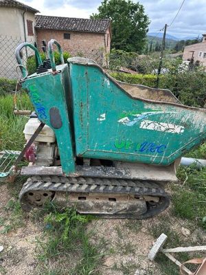 une machine verte qui est à l'arrêt dans la boue