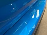 a close up of a blue car parked in a garage