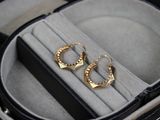 deux paires de boucles d'oreilles dans un écrin posé sur une table