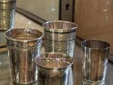 Plusieurs coupes en argent sont alignées sur une table devant un miroir