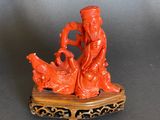 an orange figurine of a man and a woman sitting on a rock