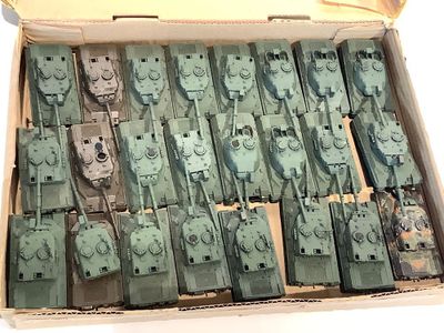 une boîte remplie de petits chars de combat posée sur une table