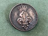 une image représentant un bouton en métal orné d'une couronne