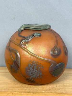 a brown vase with a lizard on it sitting on a table