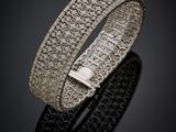 gros plan d'un bracelet en argent sur une surface noire