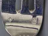 a silver fork with a hole in the middle of it
