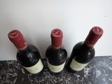 three bottles of wine are lined up on a counter top