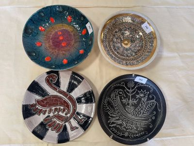 three plates with designs on them sitting on a table