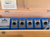 four blue batteries in a wooden box on a table