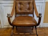 a brown leather chair sitting in front of a white door