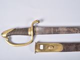 an old sword with a brass handle on a white surface