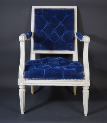 a white chair with blue velvet upholstered seat