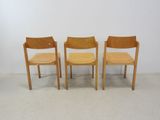 three wooden chairs sitting next to each other in a room