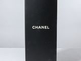 un flacon de parfum Chanel posé sur une surface blanche, sur fond blanc