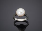 a white pearl ring on a black surface