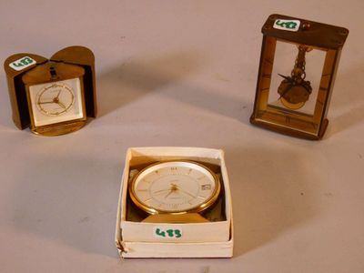 three small clocks sitting in a box on a table