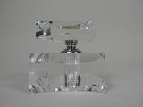 un flacon de parfum en verre transparent muni d'un bouchon argenté