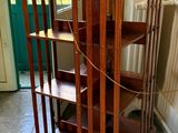 a wooden book shelf with a clock on top of it