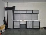 an image of a garage with a work bench and cabinets