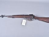 an old rifle with a wooden barrel and a tag on it