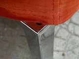 a close up of a red chair on a tile floor