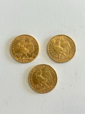 three gold coins are sitting on a white surface