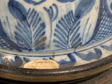 a close up of a blue and white vase on a table