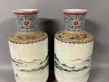 pair of chinese vases with colorful designs on them sitting on a table