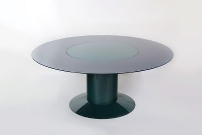 une table ronde en verre avec un piètement noir et un plateau circulaire en verre