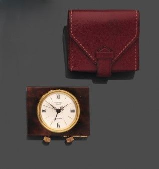 une horloge et un portefeuille posés l'un à côté de l'autre sur une table