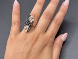 the woman ' s hand is holding a ring with a flower on it