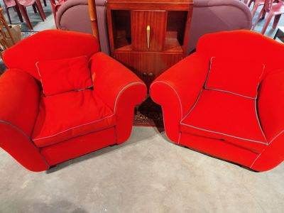 deux chaises rouges placées l'une à côté de l'autre dans une pièce