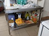 une cuisine équipée d'une table en inox et d'un micro-ondes