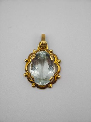 une photo d'un pendentif en or orné d'une aigue-marine