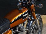 an orange motorcycle parked on the side of the street