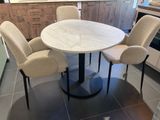 quatre chaises disposées autour d'une table ronde dans une cuisine