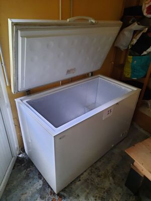 a white chest freezer sitting in the corner of a room